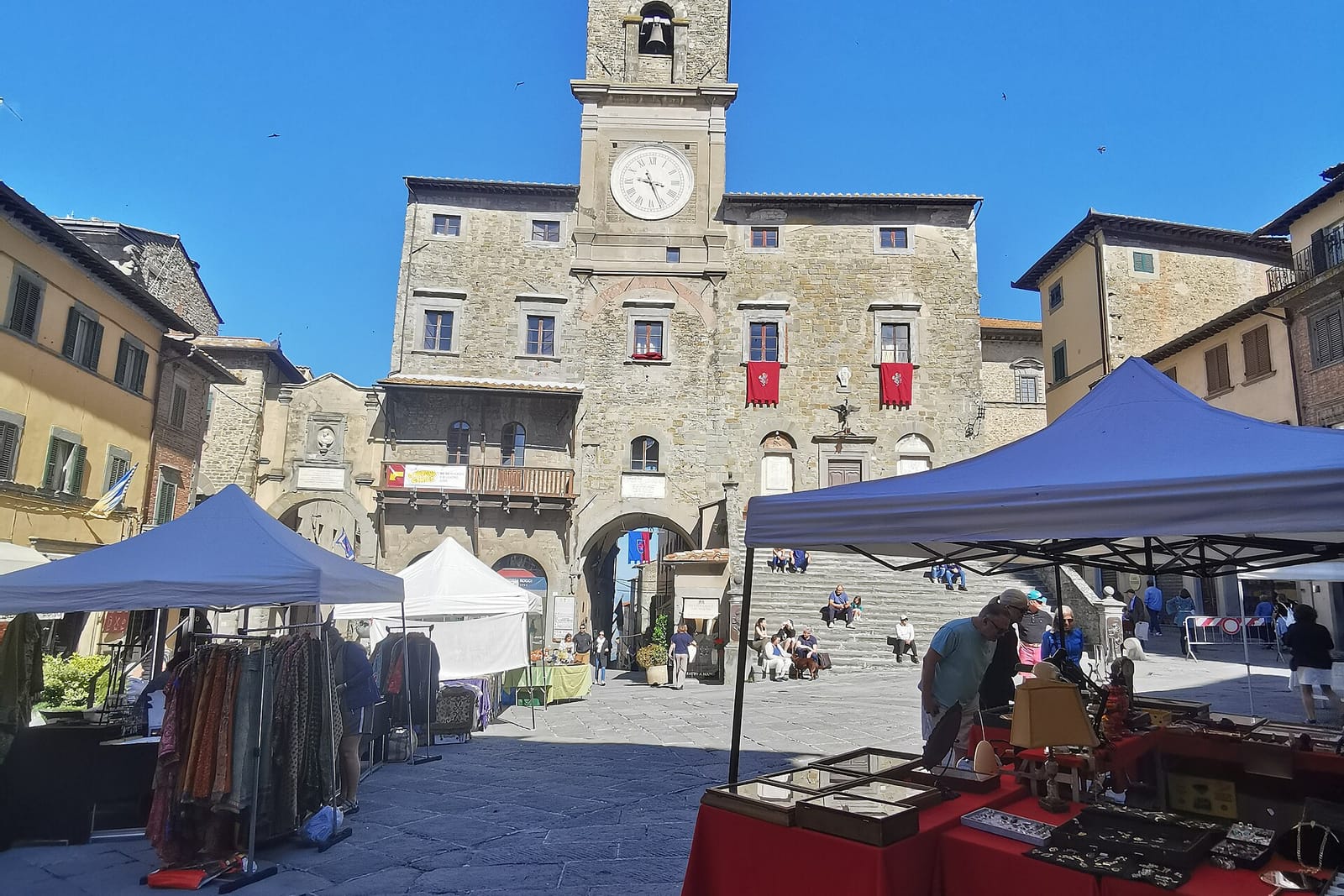 La Piazza della Repubblica de Cortona con la escalinata del Palacio Comunal y los puestos del mercado