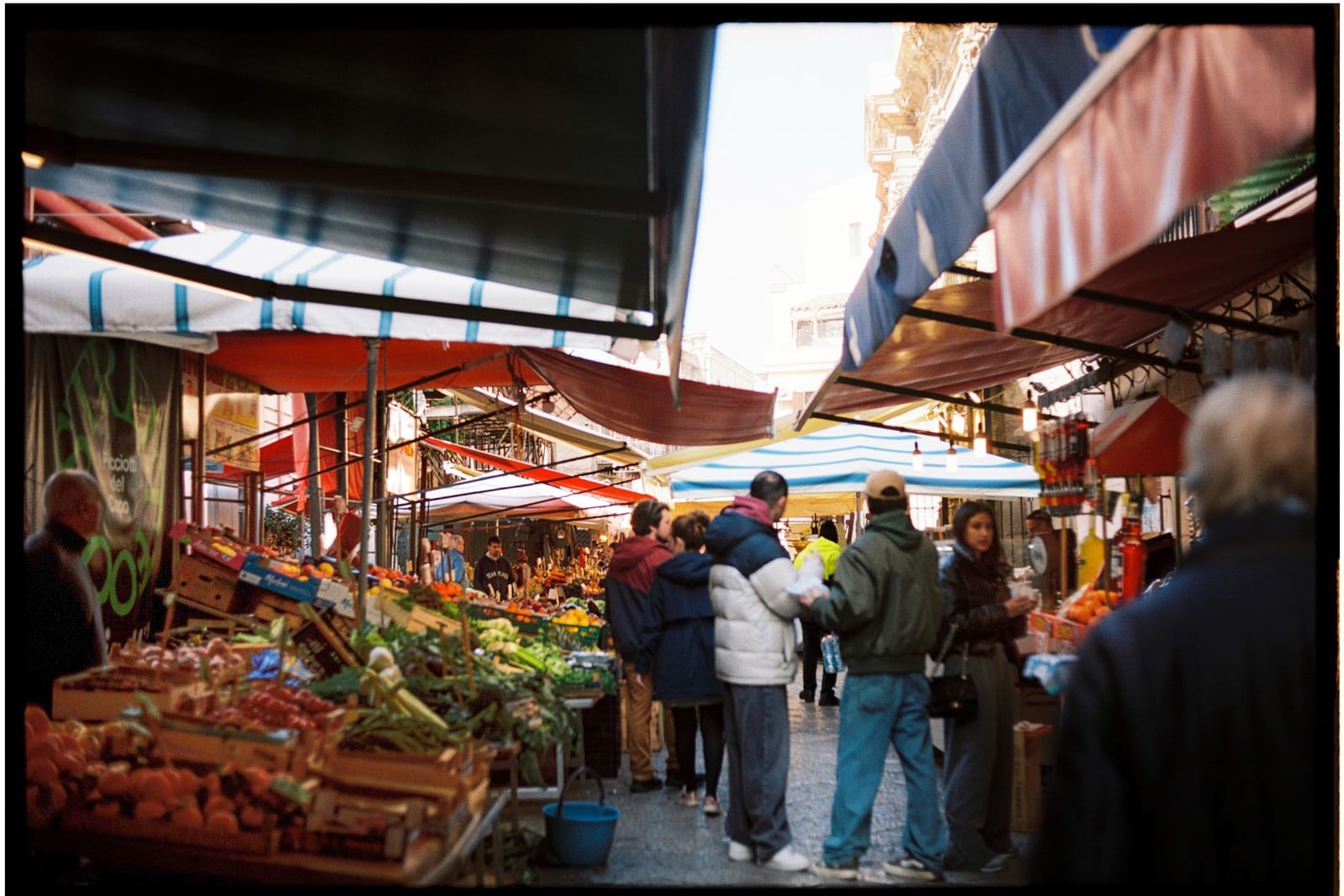 The stalls of an Italian weekly market, fruit and vegetables under the awnings