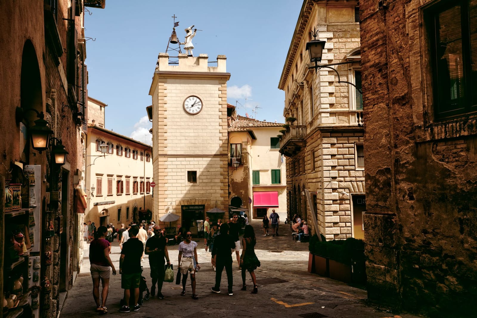 The climbing Corso of Montepulciano, with the clock tower and wine-shop windows