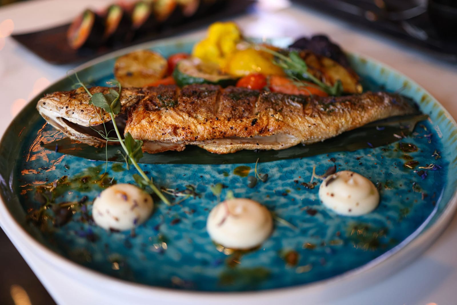 A plate of cooked lake fish, plated in a restaurant