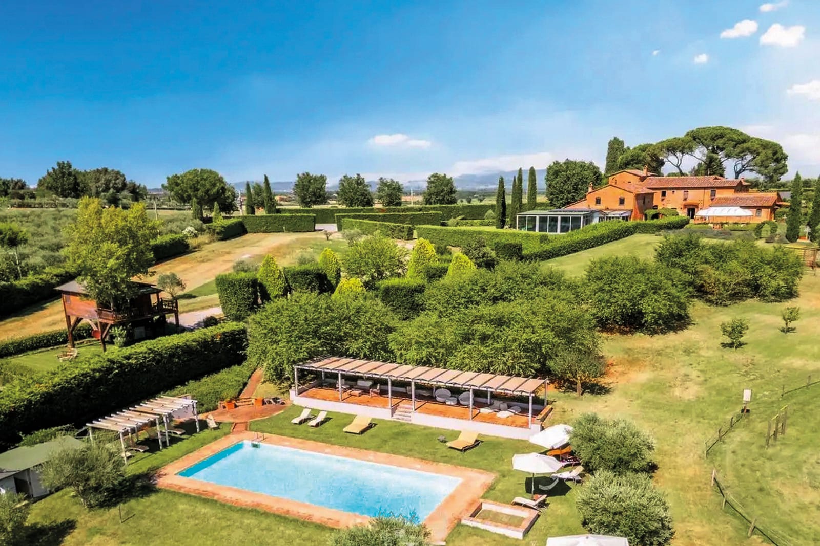 La proprietà vista dall'alto, con l'edificio in mattoni, la piscina e l'uliveto intorno