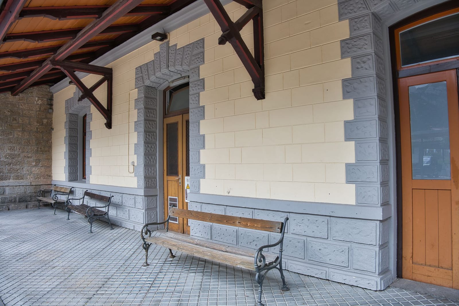 El andén de una pequeña estación de pueblo, con el banco y la puerta de la sala de espera