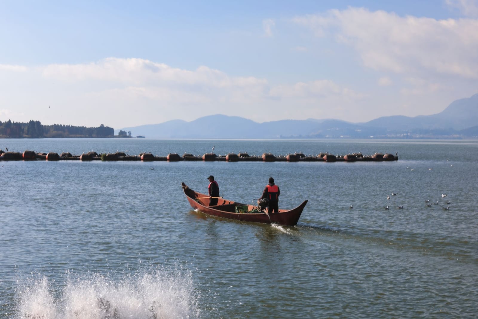 Ein Fischerboot auf dem Trasimenischen See, dahinter eine Insel