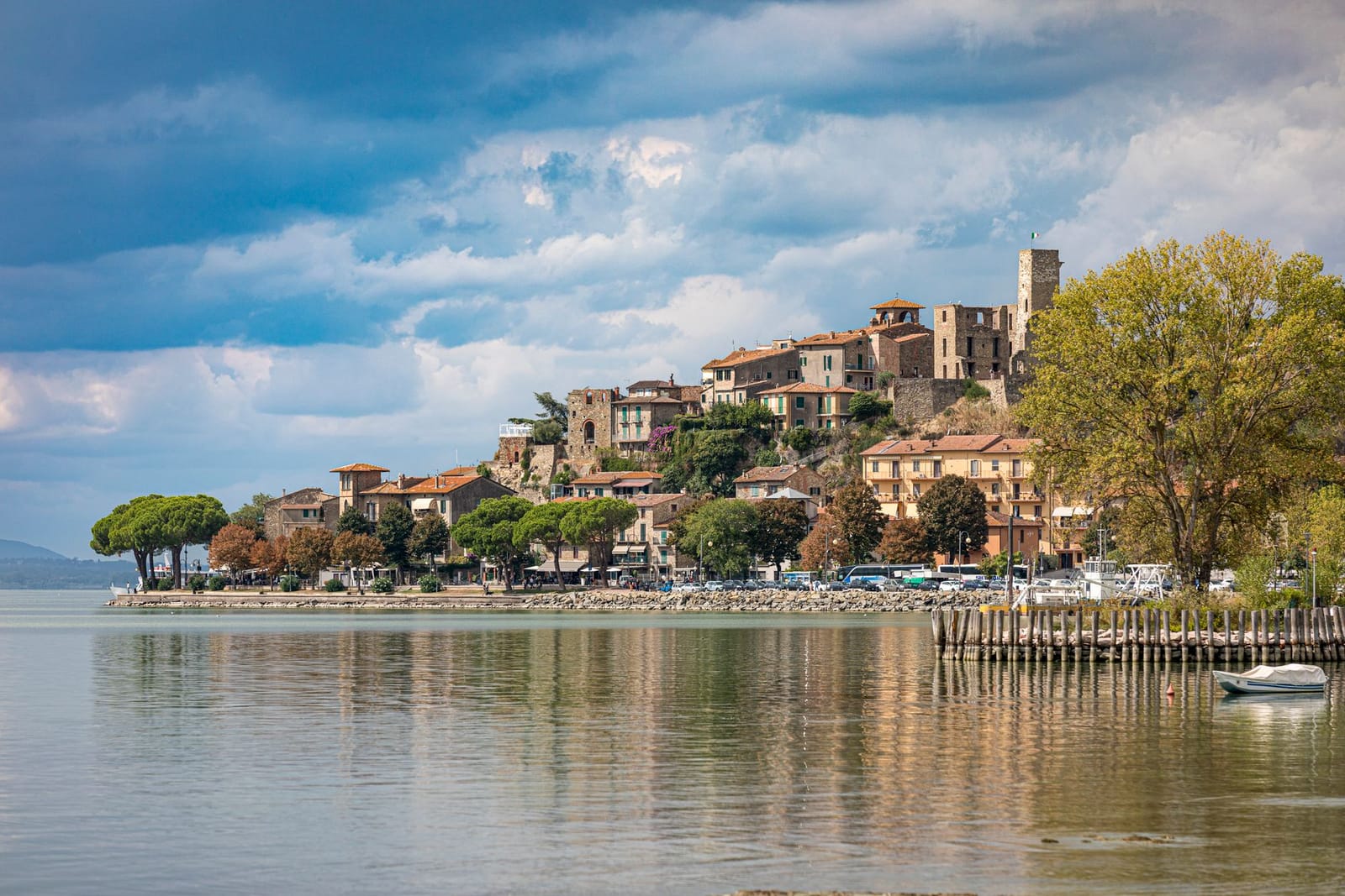 Passignano sul Trasimeno seen from the water, houses climbing from the lakefront up to the castle